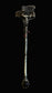 A gothic-style decorative staff or wand with a dark, textured top, small red gem accents, and a faceted dark gemstone at the bottom, photographed against a dark background.