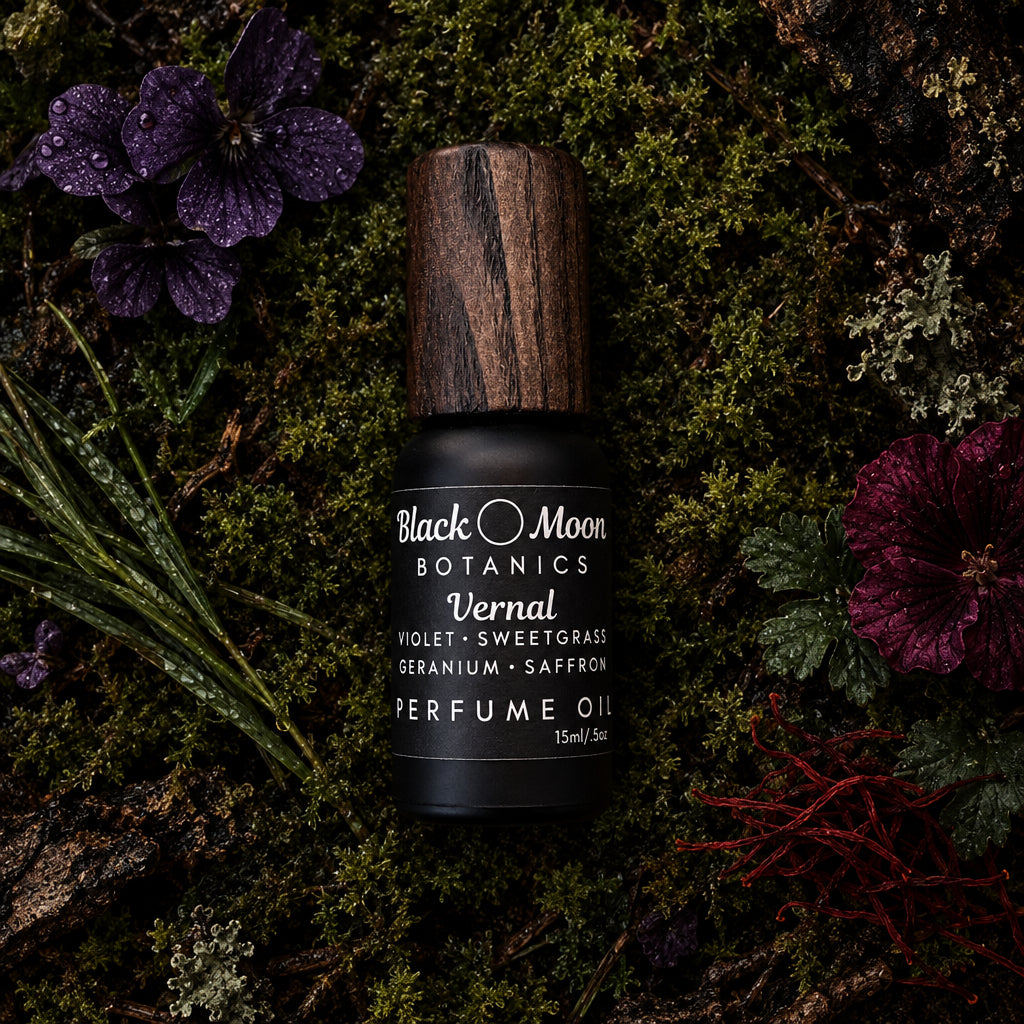 A perfume oil bottle with a dark wood-grain cap and a black label, lying on a textured brown and beige surface. The label reads 'Black Moon Distillations Lavandal'.